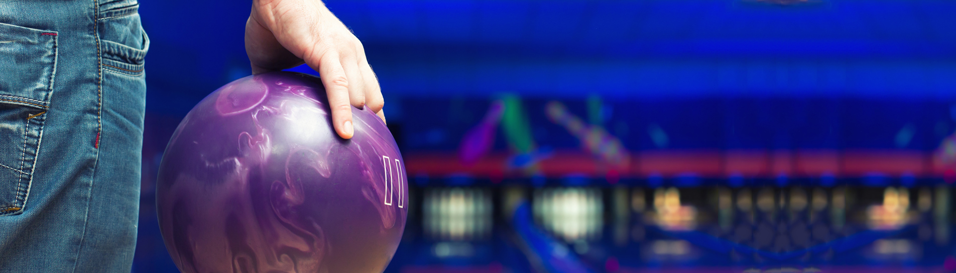 Man Holding Ball Against Bowling Alley